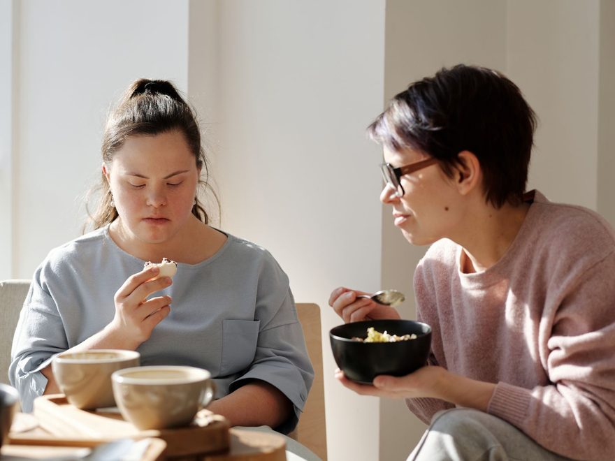 Caregiver support in Bryant, Arkansas: a caregiver shares a meal at home with a young woman with Down syndrome.